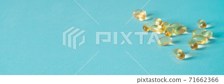 Pile of capsules Omega 3 on blue background. Close up, top view. 71662366