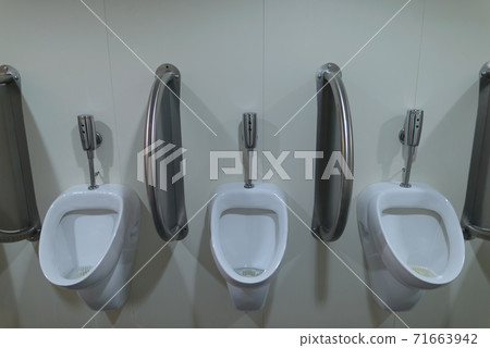 Three ceramic urinals inside the men's public toilet Three ceramic urinals inside the men's public toilet 71663942