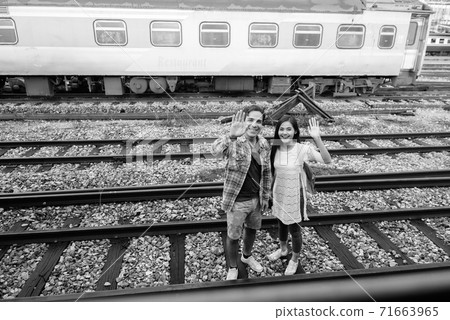 Persian tourist man and young Asian tourist woman together at the railway station Persian tourist man and young Asian tourist woman together at the railway station 71663965