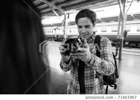 Persian tourist man and young Asian tourist woman together at the railway station Persian tourist man and young Asian tourist woman together at the railway station 71663967