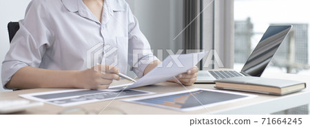 Chief marketing officer in Asia is analyzing the company's financial growth graph using personal computers for work, Working at home concept. Chief marketing officer in Asia is analyzing the company's financial growth graph using personal computers for work, Working at home concept. 71664245