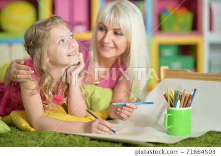 Portrait of girl with mother drawing at home Portrait of girl with mother drawing at home 71664503
