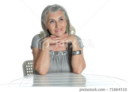 Portrait of emotional senior woman at table Portrait of emotional senior woman at table 71664510
