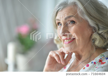 Portrait of happy senior woman posing at home Portrait of happy senior woman posing at home 71664604