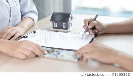 Real estate agent or sales manager has proposed terms and conditions to customers who sign house purchase agreements with insurance, Agreement to sign the purchase contract concept. Real estate agent or sales manager has proposed terms and conditions to customers who sign house purchase agreements with insurance, Agreement to sign the purchase contract concept. 71665228