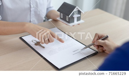 Real estate agent or sales manager has proposed terms and conditions to customers who sign house purchase agreements with insurance, Agreement to sign the purchase contract concept. 71665229