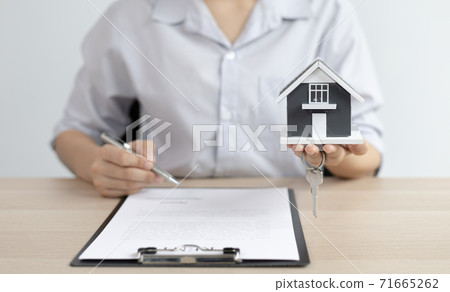 Sales manager or real estate agent prepares to hand over the keys and the house together with the insurance to the customer, Attention to property services and insurance concept. Sales manager or real estate agent prepares to hand over the keys and the house together with the insurance to the customer, Attention to property services and insurance concept. 71665262