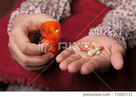 Close up of women hand taking pills Close up of women hand taking pills 71665711
