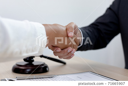 Lawyers or counselors join hands with clients to congratulate the end of the case by the company, Negotiation or settlement of lawsuits concept. 71665907