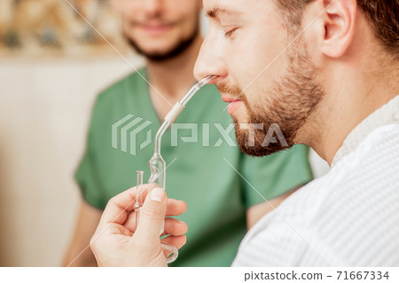 Man receives nasal inhalation. 71667334