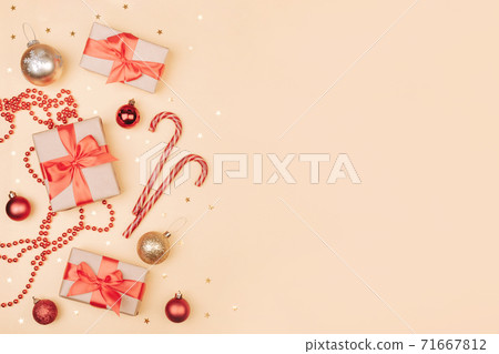Christmas and New Year backdrop with copy space. Festively decorated Gift boxes, cane lollypops, christmas balls on golden banner. Christmas and New Year backdrop with copy space. Festively decorated Gift boxes, cane lollypops, christmas balls on golden banner. 71667812