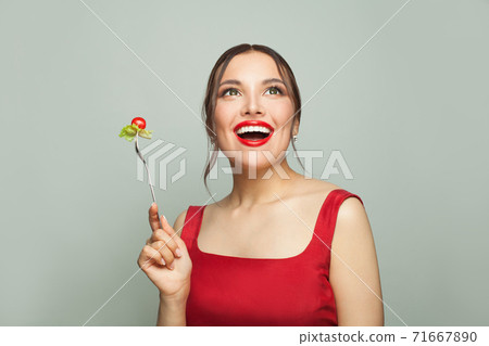 Beautiful happy woman eating healthy food 71667890