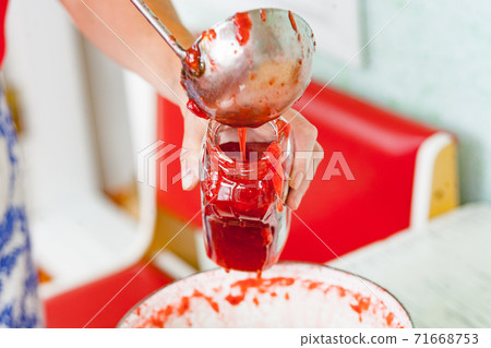 pour fresh strawberry jam into a jar with steel ladle pour fresh strawberry jam into a jar with steel ladle 71668753