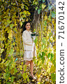 Warm autumn portrait of young pretty woman. 71670142
