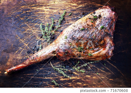 Traditional barbecue aged leg of venison sliced with herbs  71670608