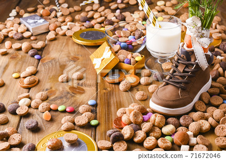 Dutch holiday postcard Sinterklaas. Wooden background with childrens shoe with carrots for Santa's Dutch holiday postcard Sinterklaas. Wooden background with childrens shoe with carrots for Santa's 71672046