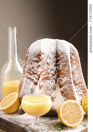 Limoncello with a glass on the table and a soft star-shaped pasta sprinkled with icing sugar.  71672068
