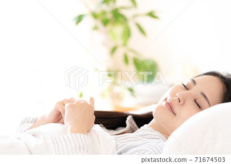 Young woman waking up in the bedroom 71674503