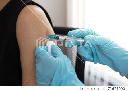 Doctor is vaccinating women with antibiotics or new antibodies to prevent the spread of the virus, Vaccination against communicable diseases concept Doctor is vaccinating women with antibiotics or new antibodies to prevent the spread of the virus, Vaccination against communicable diseases concept 71675990