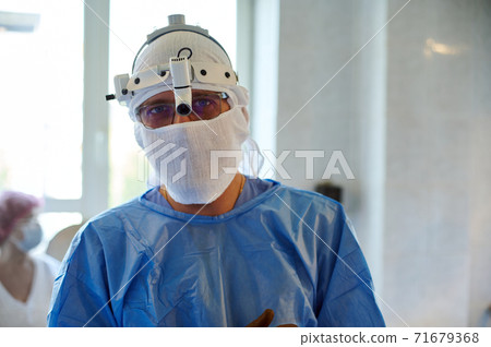 Portrait of a surgeon with a headlamp in the operating room. Before the operation. 71679368