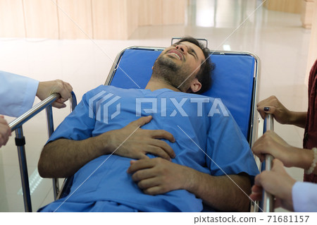 Abdominal pain patient lying in a gurney Abdominal pain patient lying in a gurney 71681157