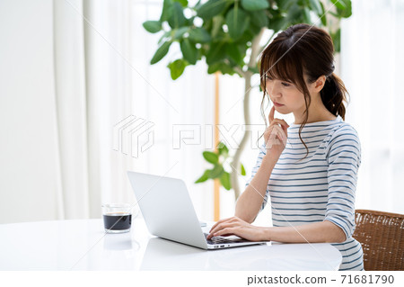 A woman doing telework in the living room. A woman doing telework in the living room. 71681790