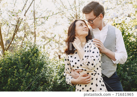 Young man and woman couple in a blooming garden Young man and woman couple in a blooming garden 71681965
