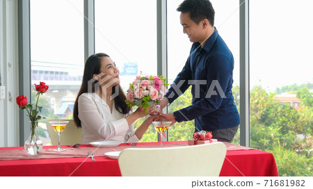Romantic couple giving gift to lover at restaurant 71681982