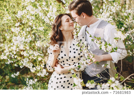 Young man and woman couple in a blooming garden Young man and woman couple in a blooming garden 71681983