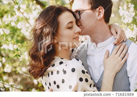 Young man and woman couple in a blooming garden 71681989