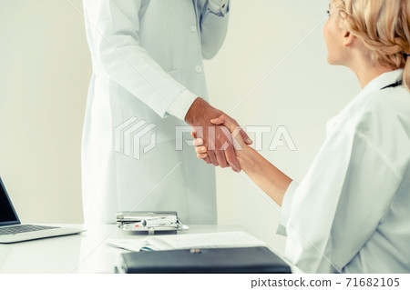 Doctor at hospital shakes hand with another doctor 71682105
