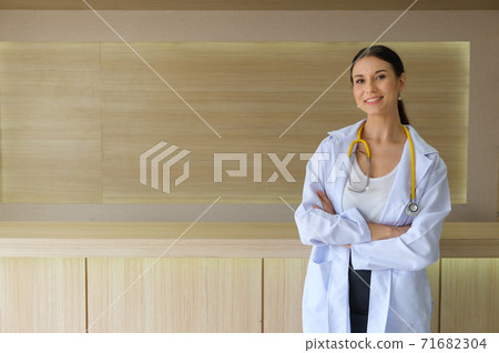 The female doctor was holding her arms smiling in the reception hall. The female doctor was holding her arms smiling in the reception hall. 71682304