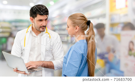 Doctors at hospital working with another doctor. Doctors at hospital working with another doctor. 71683700