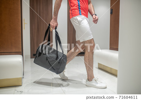 Close up picture of mans figure entering the changing room in the gym 71684611