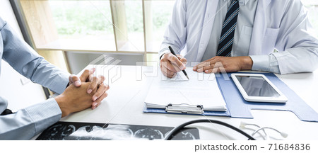 Professor Doctor consulting with patient discussing something and recommend treatment methods, Presenting results on report and x-ray film, Medicine and health care concept Professor Doctor consulting with patient discussing something and recommend treatment methods, Presenting results on report and x-ray film, Medicine and health care concept 71684836