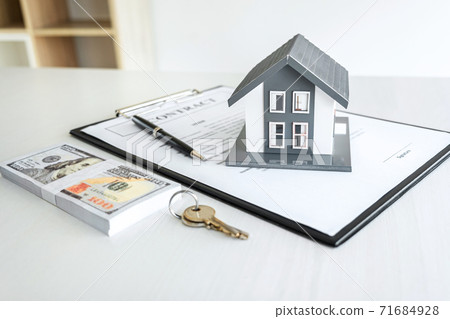 House model and Money, house key lying on real estate contract, home loan and investment concept House model and Money, house key lying on real estate contract, home loan and investment concept 71684928
