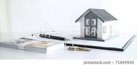 House model and Money, house key lying on real estate contract, home loan and investment concept House model and Money, house key lying on real estate contract, home loan and investment concept 71684930