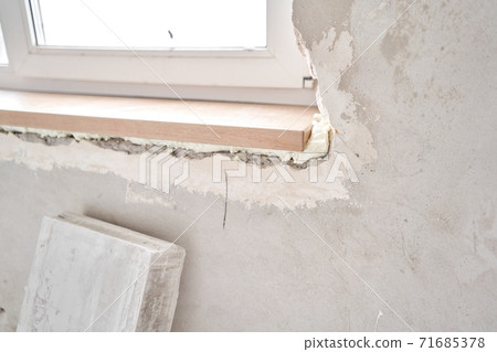 Wooden window sill, plywood covered with oak veneer. Window sill installation process. Interior design, building, home improvement, diy concept. Wooden window sill, plywood covered with oak veneer. Window sill installation process. Interior design, building, home improvement, diy concept. 71685378