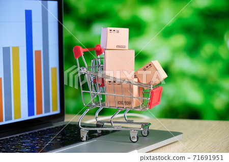 The concept of purchasing goods online. Store cart with boxes on a laptop The concept of purchasing goods online. Store cart with boxes on a laptop 71691951
