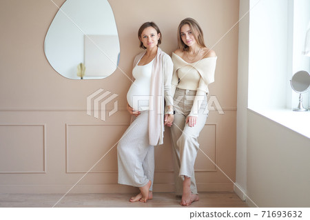 Lesbian couple waiting for baby, woman posing with her pregnant girlfriend Lesbian couple waiting for baby, woman posing with her pregnant girlfriend 71693632