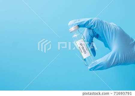 COVID-19 Vaccine vial against Coronavirus infection in hand of doctor with Nitrile Glove in hospital laboratory. Medical, health, Vaccination and immunization concept COVID-19 Vaccine vial against Coronavirus infection in hand of doctor with Nitrile Glove in hospital laboratory. Medical, health, Vaccination and immunization concept 71693791