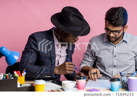 Two businessmen speaking and working at the office Two businessmen speaking and working at the office 71694233