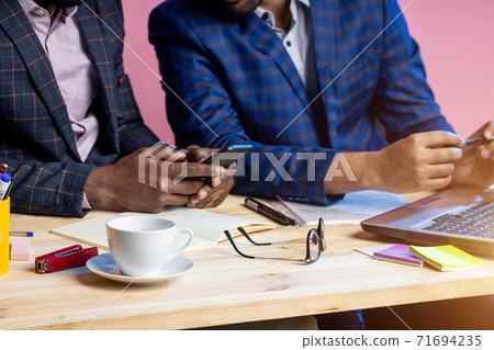 Two businessmen speaking and working at the office Two businessmen speaking and working at the office 71694235