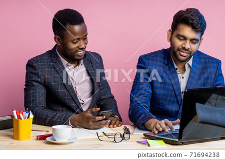 Two businessmen speaking and working at the office Two businessmen speaking and working at the office 71694238