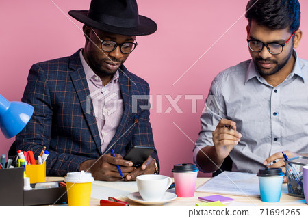 Two businessmen speaking and working at the office Two businessmen speaking and working at the office 71694265
