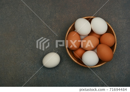 Bowl of brown and white chicken eggs on table 71694484