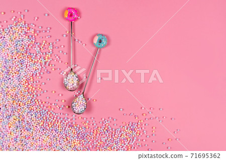 Pile of pastel color sugar balls with spoons on pink background with copyspace. Mixed colorful candies for sweets decoration. Rainbow colored sugar candies, dragee, confectionery. Sweets and desserts Pile of pastel color sugar balls with spoons on pink background with copyspace. Mixed colorful candies for sweets decoration. Rainbow colored sugar candies, dragee, confectionery. Sweets and desserts 71695362
