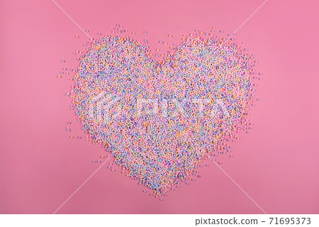 Heart made of pastel color balls on pink. Styrofoam or Polystyrene foam background. Mixed colorful sugar balls for sweets decoration. Rainbow colored sugar candies, dragee, confectionery. Love concept Heart made of pastel color balls on pink. Styrofoam or Polystyrene foam background. Mixed colorful sugar balls for sweets decoration. Rainbow colored sugar candies, dragee, confectionery. Love concept 71695373