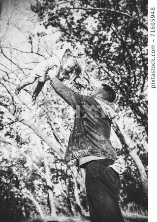 Happy father and little cute daughter walking down the forest path in autumn sunny day 71695948