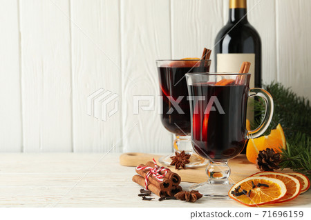 Bottle of wine, cups of mulled wine and ingredients on wooden background Bottle of wine, cups of mulled wine and ingredients on wooden background 71696159